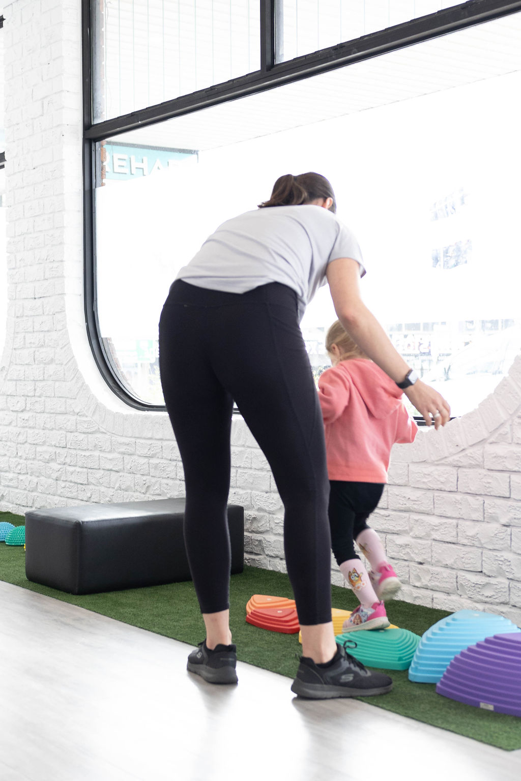 Therapist supporting child during balance exercise